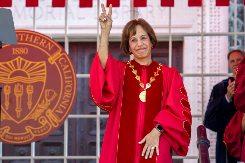 President Folt giving fight on hand sign.
