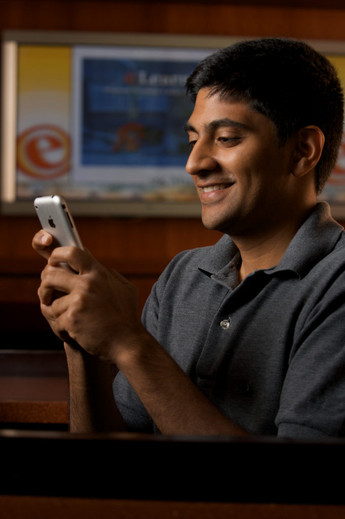 Tejas Shah, an undergradate student pursuing a degree in business administration, uses his smart phone to respond to an in-class polling.